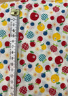 Fabric with colorful apple pattern and ruler for scale