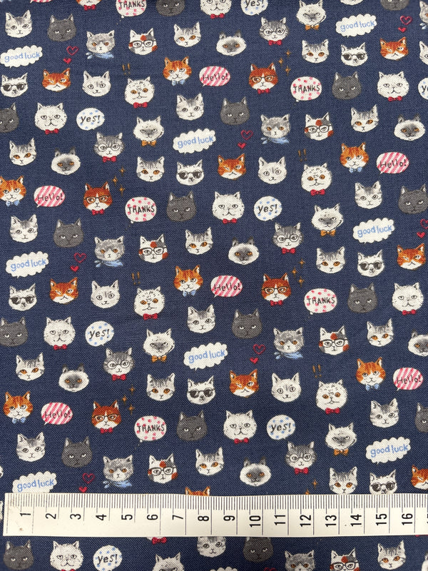 Patterned fabric with cartoonish animal faces on a blue background, accompanied by a ruler for scale.
