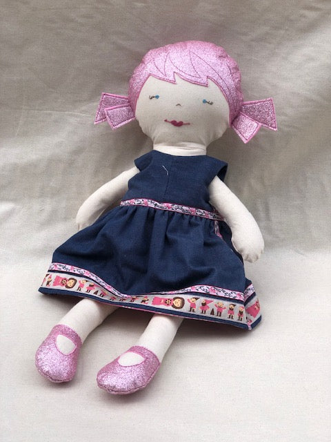 Doll with a blue dress and pink shoes on a light gray background