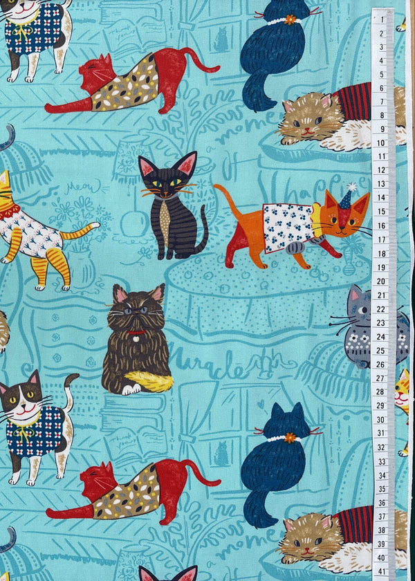 Fabric with a pattern of cartoon cats on a blue background