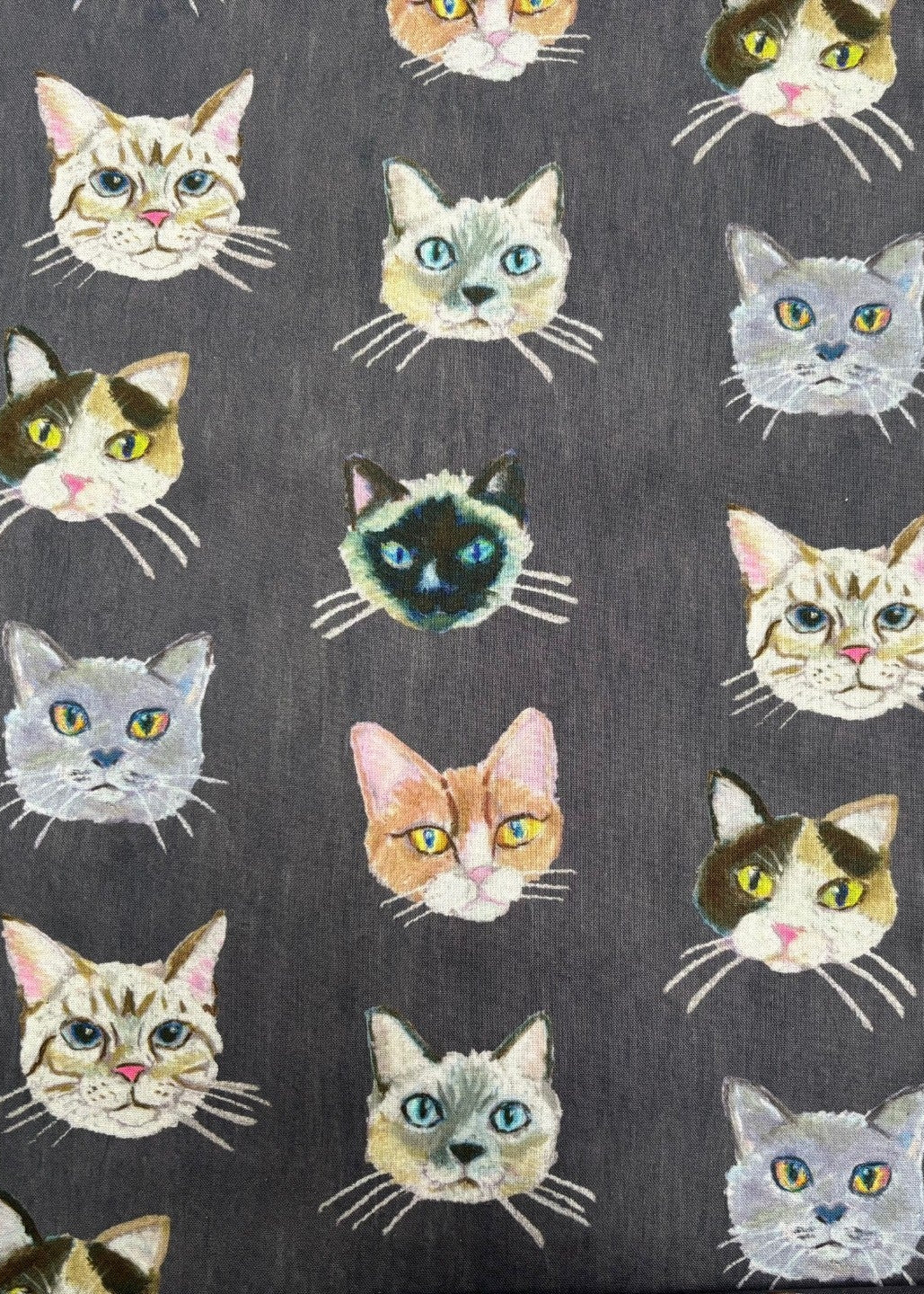 Pattern of stylized cat faces on a dark background
