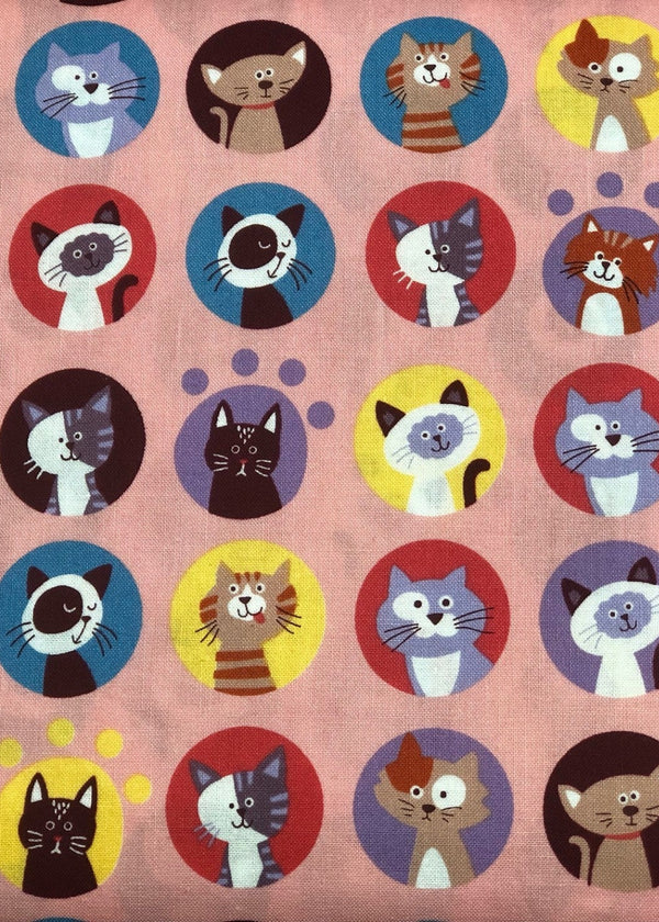 Pattern of cartoon cats in various colors on a pink background